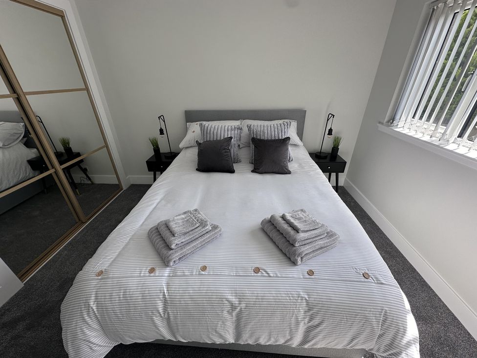 A bedroom with a bed and nightstands at 22 Fraser Avenue