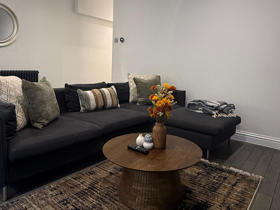 A living room with a sofa, coffee table, and decorative vase at Seaside Bliss in Brighton