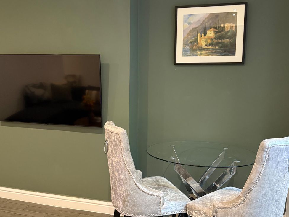 A dining room with a television and a glass table at Seaside Bliss in Brighton