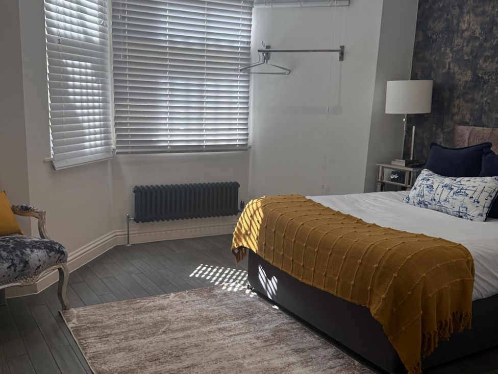 A bedroom with a bed and a chair at Seaside Bliss in Brighton
