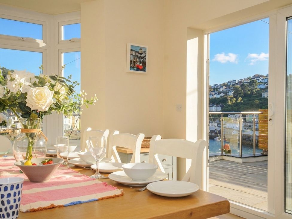 A dining room with a view overlooking the water at Barton House in Looe