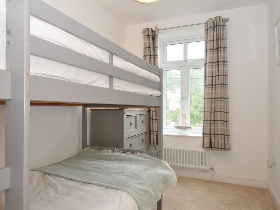 A bedroom with a bunk bed and a dresser at Barton House in Looe