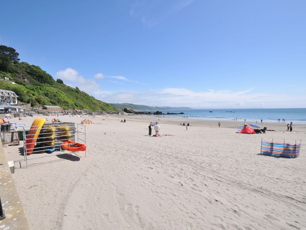 A beach scene with people and boats at Barton House in Looe
