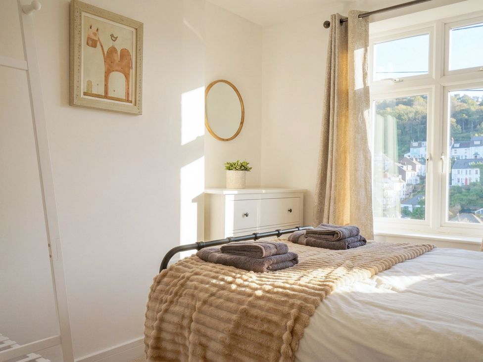 A bedroom with a bed and towels on it at Barton House in Looe