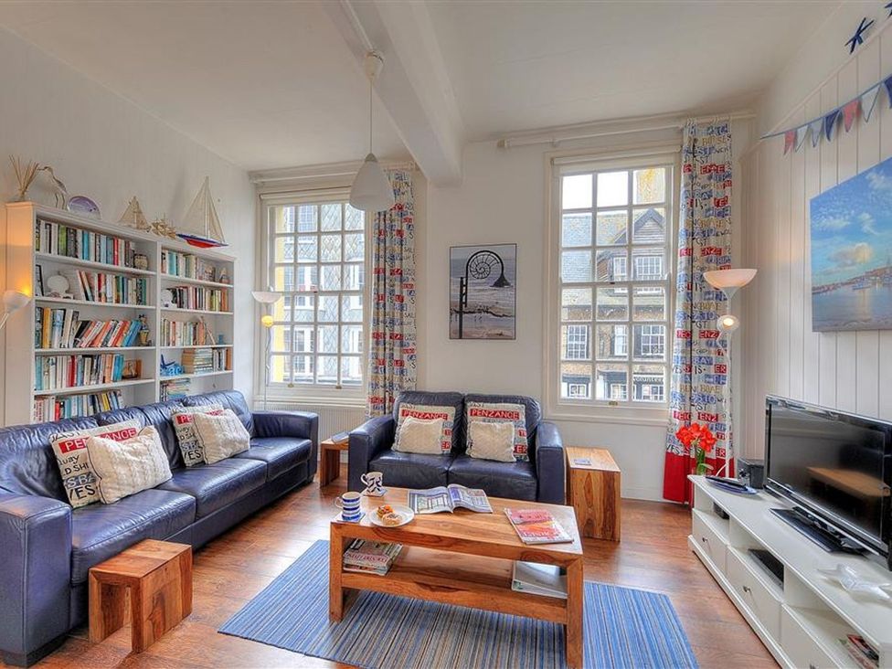 A living room with a sofa and bookshelf at 1 The Old Posthouse in Lyme Regis