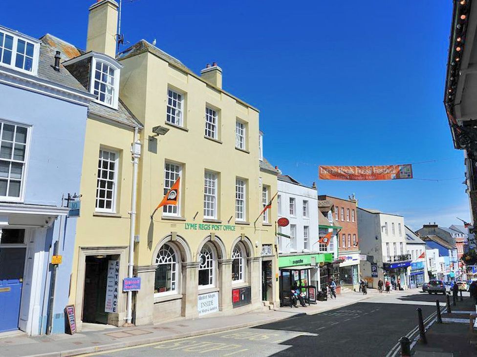 A street view featuring the Lyme Regis Post Office and various storefronts in Lyme Regis