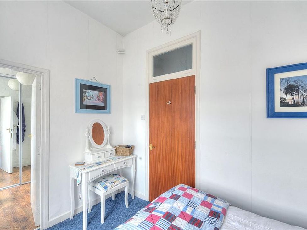 A bedroom with a dresser and bed at 1 The Old Posthouse in Lyme Regis
