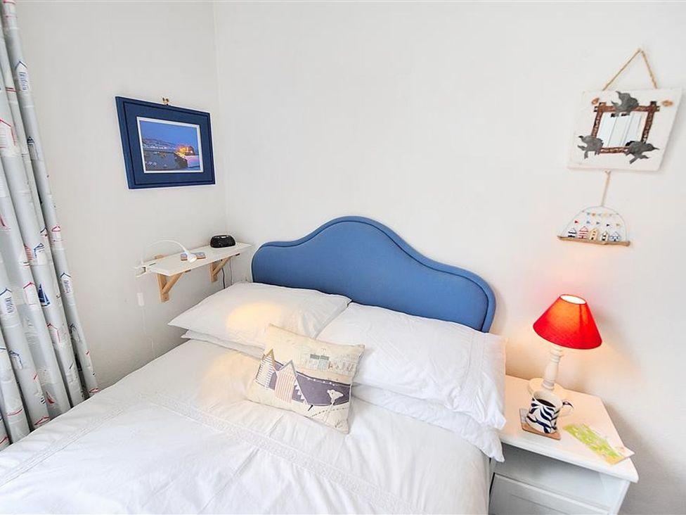 A bedroom with a bed and bedside table at 1 The Old Posthouse in Lyme Regis