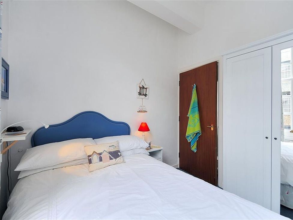 A bedroom with a blue bed and bedside table at 1 The Old Posthouse in Lyme Regis