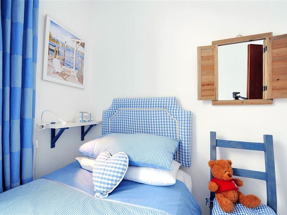 A bedroom with blue decor and a teddy bear at 1 The Old Posthouse in Lyme Regis