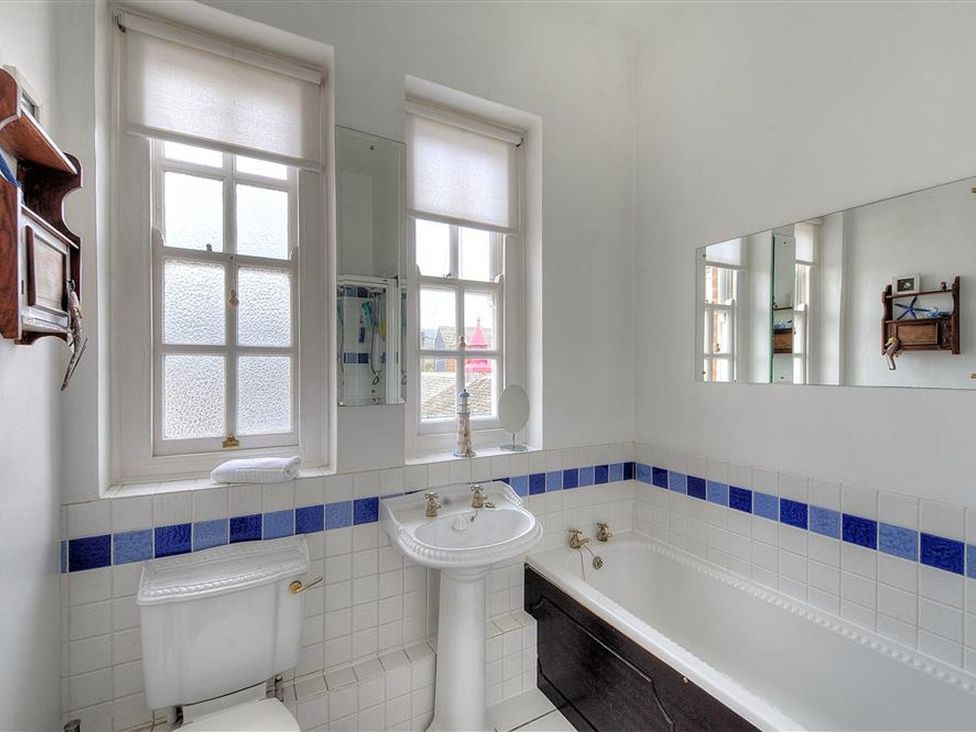A bathroom with a bathtub, toilet, and sink at 1 The Old Posthouse in Lyme Regis