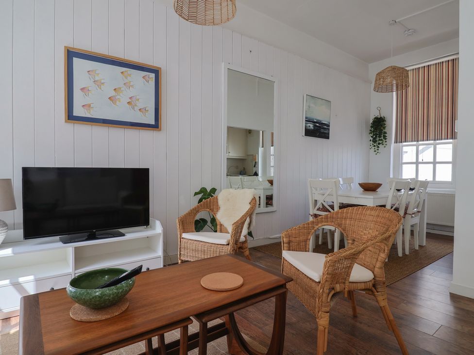 A living room with a television and dining area at 1 The Old Posthouse in Lyme Regis