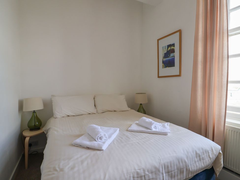 A bedroom with a bed and bedside lamp at 1 The Old Posthouse in Lyme Regis