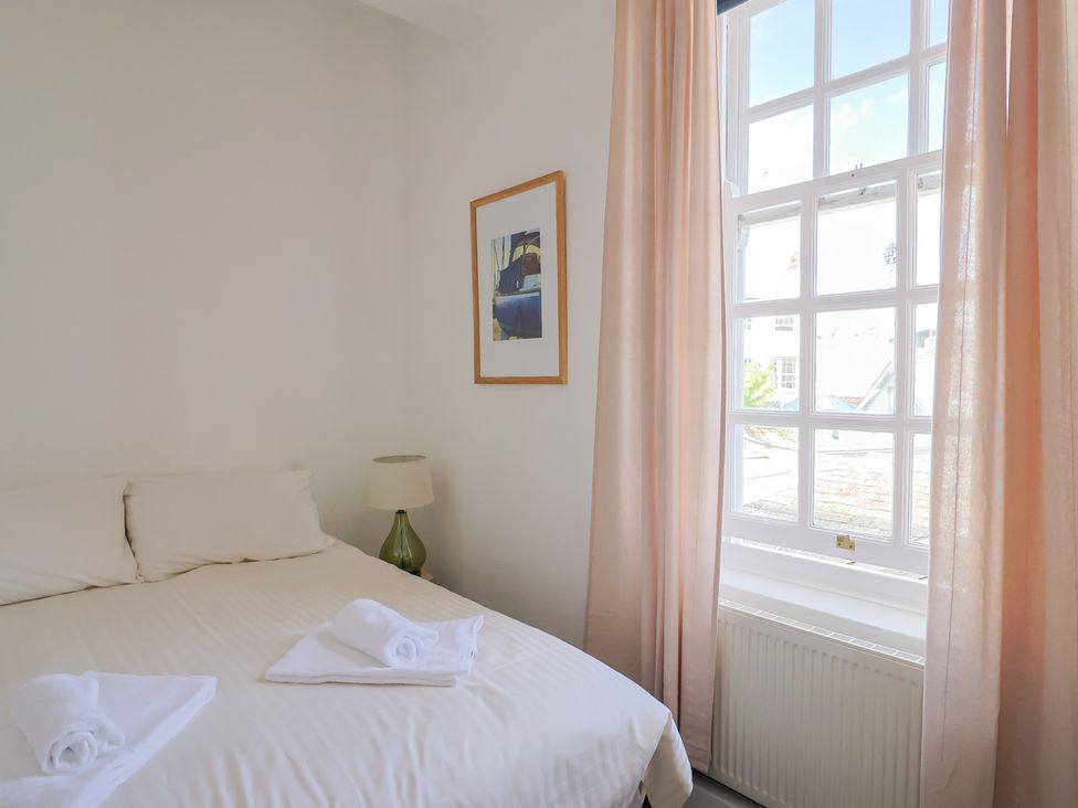 A bedroom with a bed and a lamp at 1 The Old Posthouse in Lyme Regis