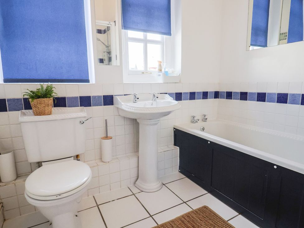 A bathroom with a sink, toilet, and bath tub at 1 The Old Posthouse in Lyme Regis