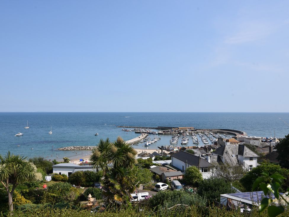 A view of boats in a marina with beach and houses at 1 The Old Posthouse in Lyme Regis
