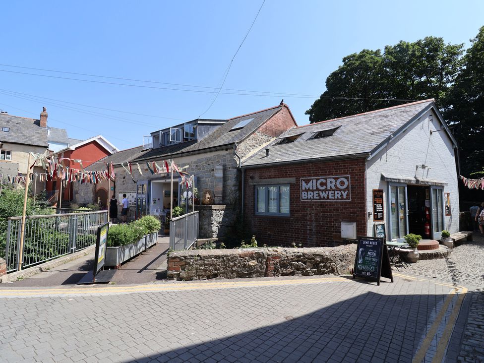 A microbrewery building with a sign and pathway at 1 The Old Posthouse Lyme Regis