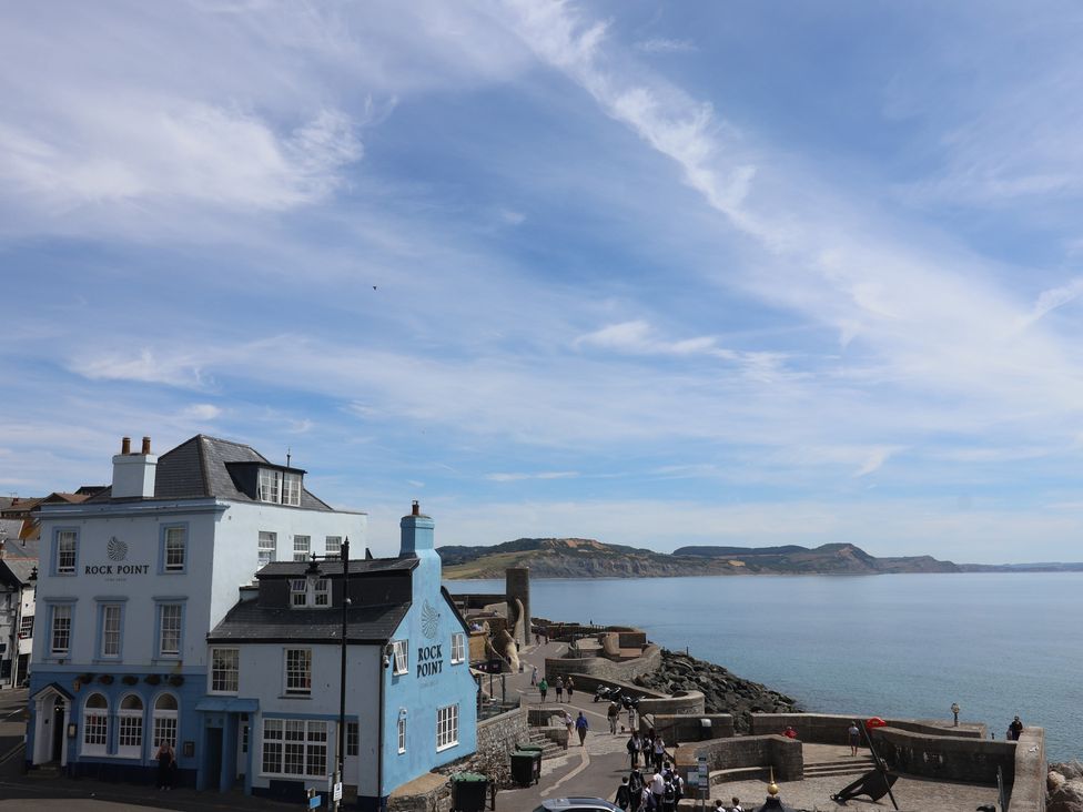A beachside scene with a building near the water at 1 The Old Posthouse in Lyme Regis