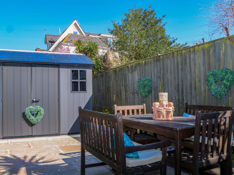 A garden with a shed and outdoor seating at The Beach House