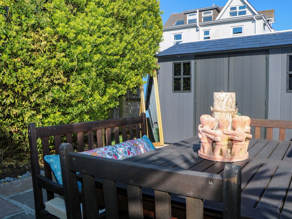 A garden with a table and chairs and a sculpture at The Beach House 