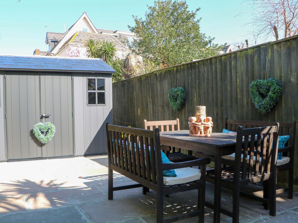 A garden with a shed and dining area at The Beach House in 