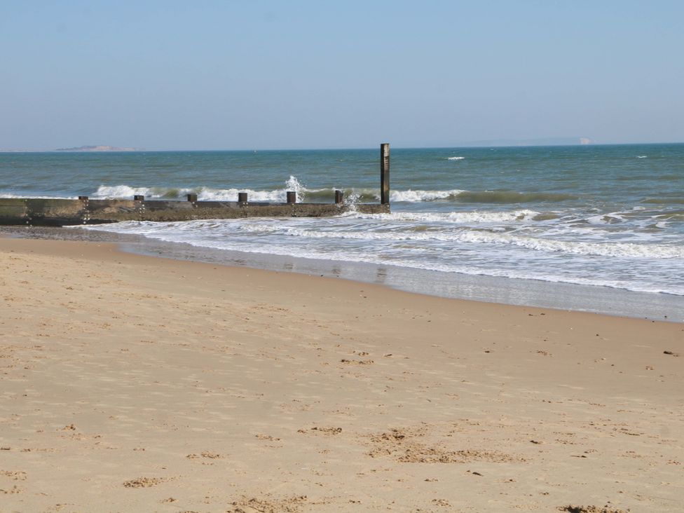 A beach with waves and a groin structure at The Beach House 