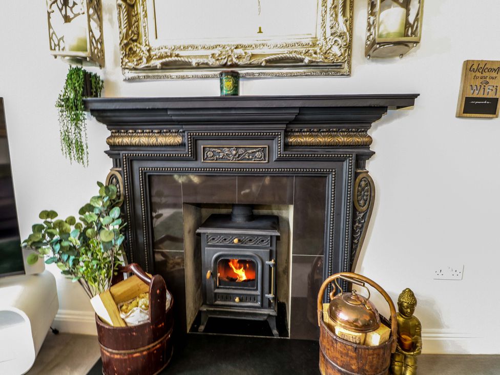 A fireplace with logs and decorative items at The Beach House in Bournemouth