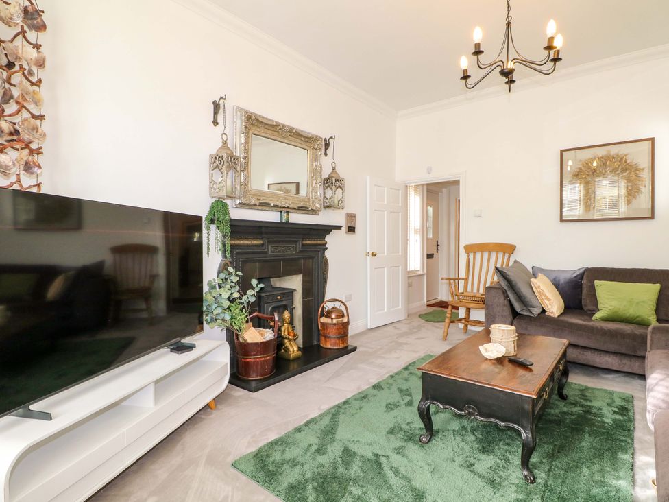 A living room with a television and coffee table at The Beach House in Bournemouth