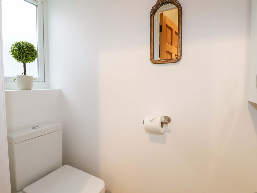 A bathroom with a toilet and a mirror at The Beach House in Bournemouth