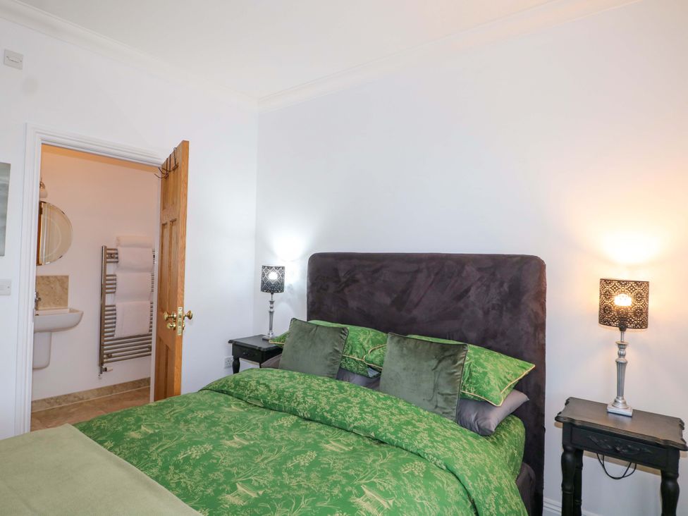 A bedroom with a bed and door to a bathroom at The Beach House in Bournemouth