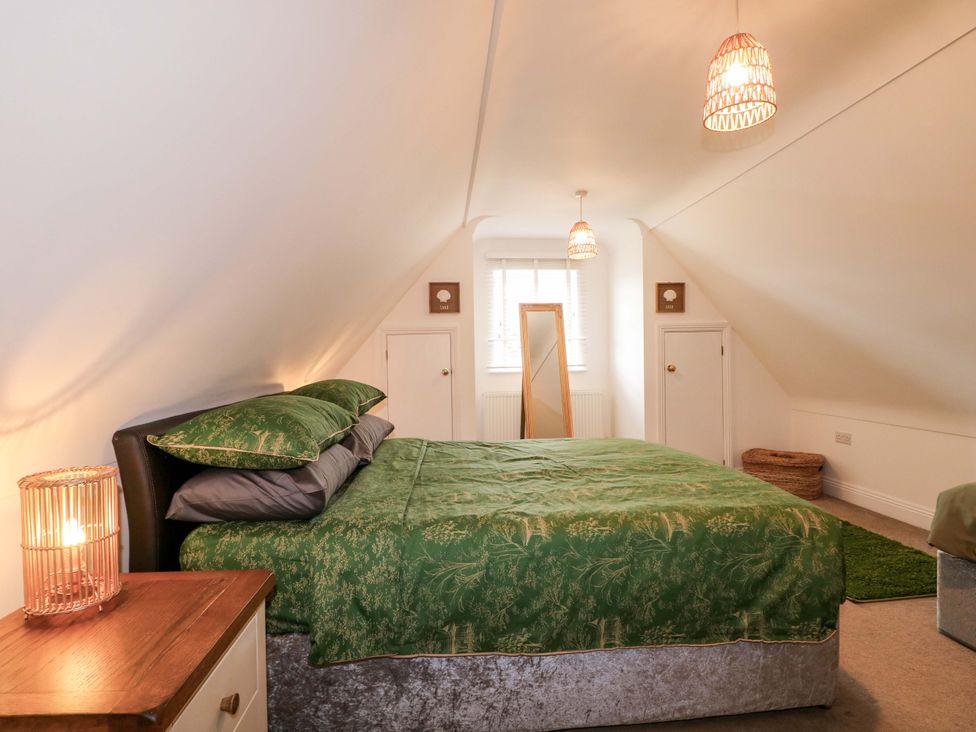 A bedroom with a bed and a mirror at The Beach House in Bournemouth