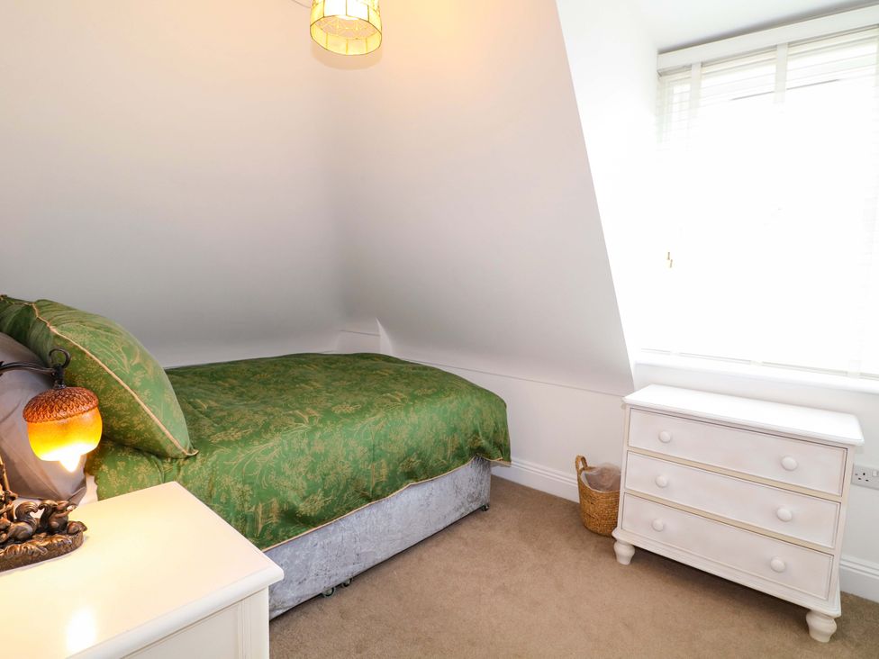 A bedroom with a bed and dresser at The Beach House in Bournemouth