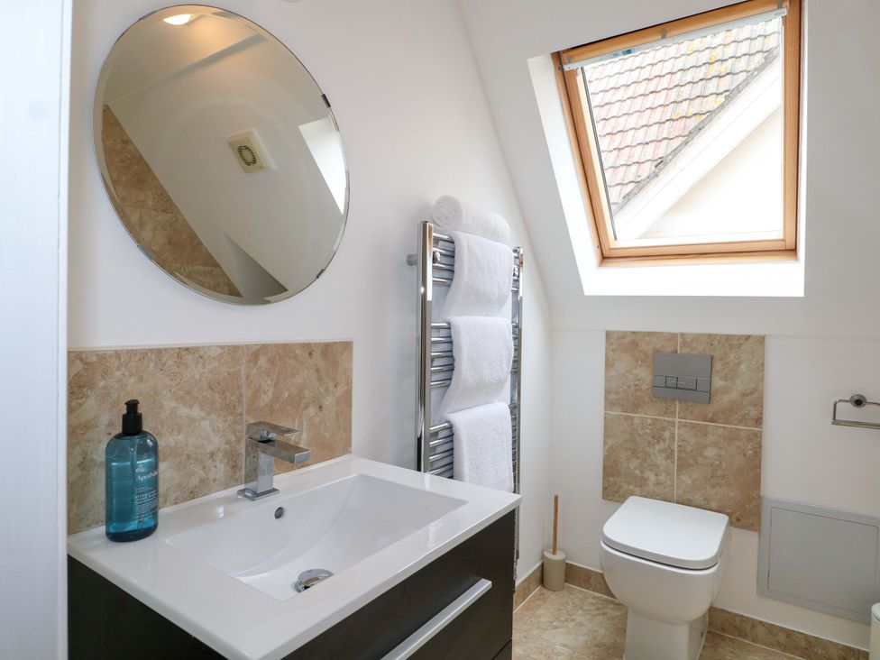 A bathroom with a sink, toilet, and towels at The Beach House in Bournemouth