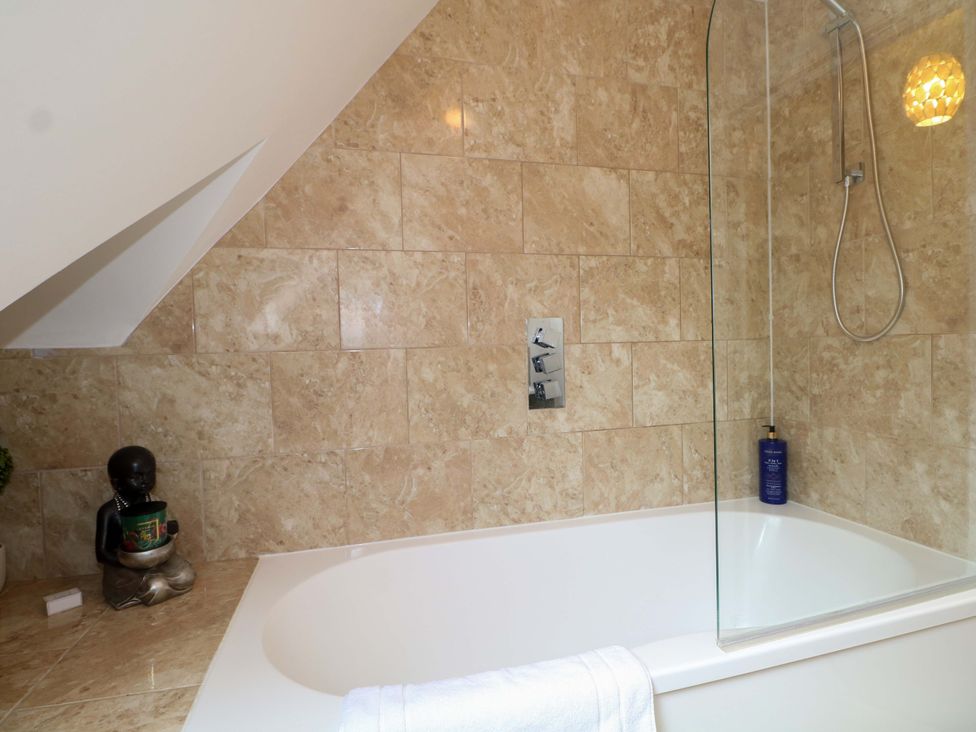 A bathroom with a bathtub and shower at The Beach House in Bournemouth