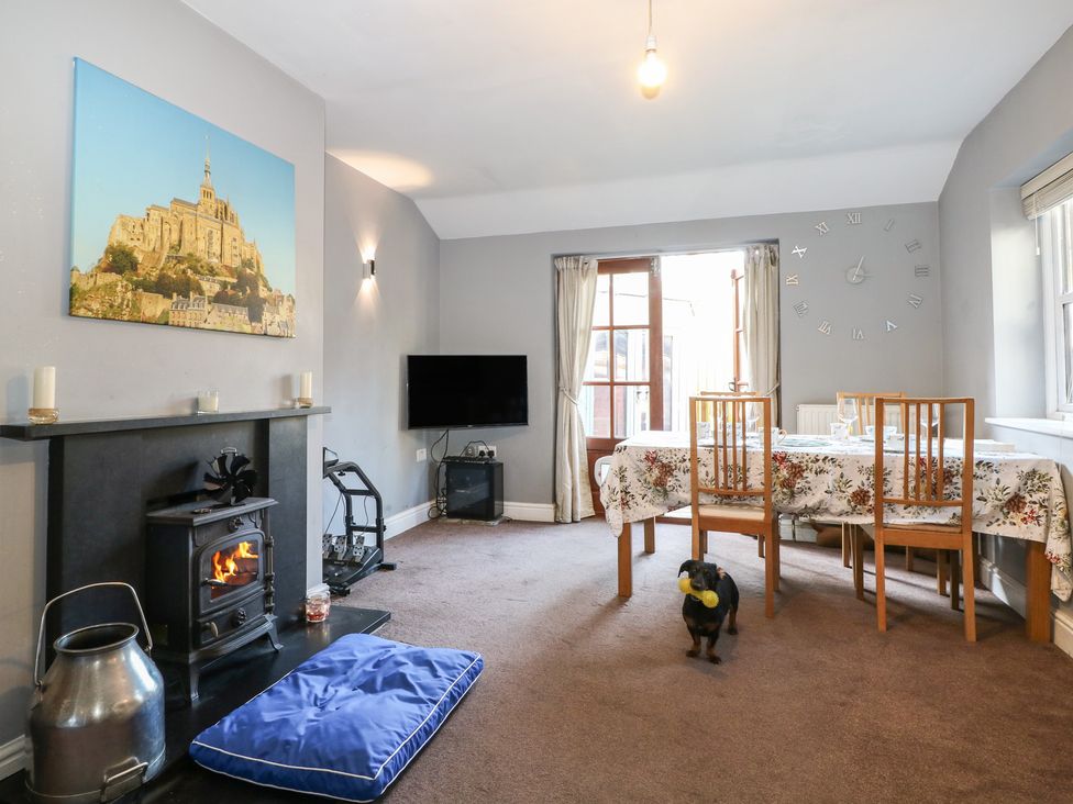 A living room with a television and a dining table at Tiffanys Coach House in Bournemouth