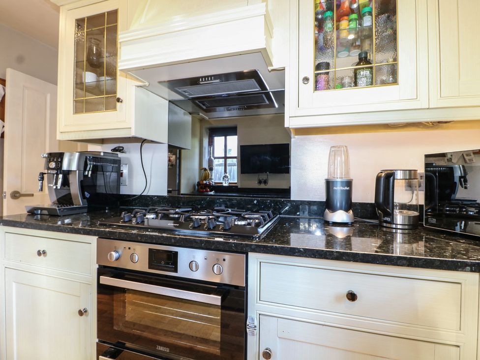 A kitchen with a stove and various appliances at Tiffanys Coach House in Bournemouth