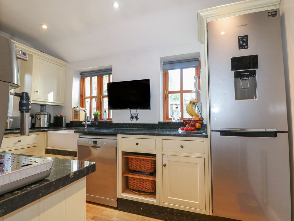 A kitchen with a refrigerator and sink at Tiffanys Coach House in Bournemouth