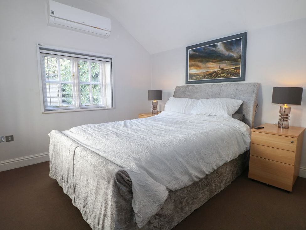 A bedroom with bed and nightstands at Tiffanys Coach House in Bournemouth