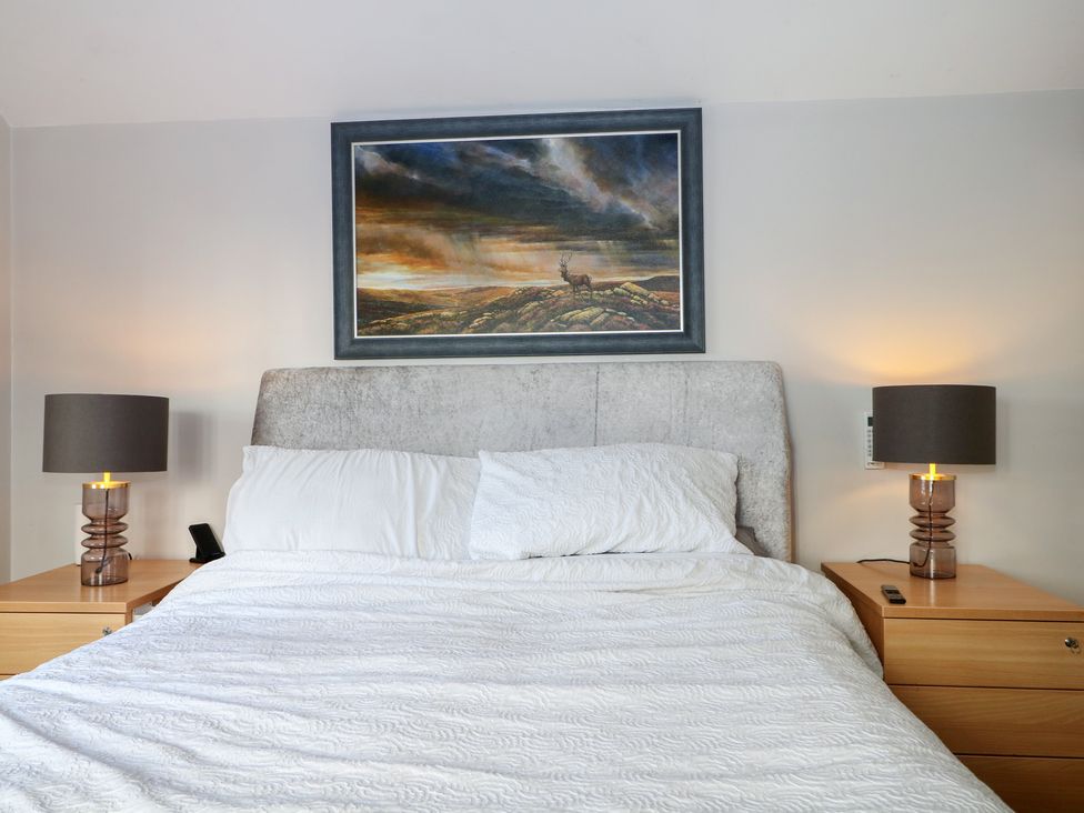 A bedroom with a bed and lamps at Tiffanys Coach House in Bournemouth