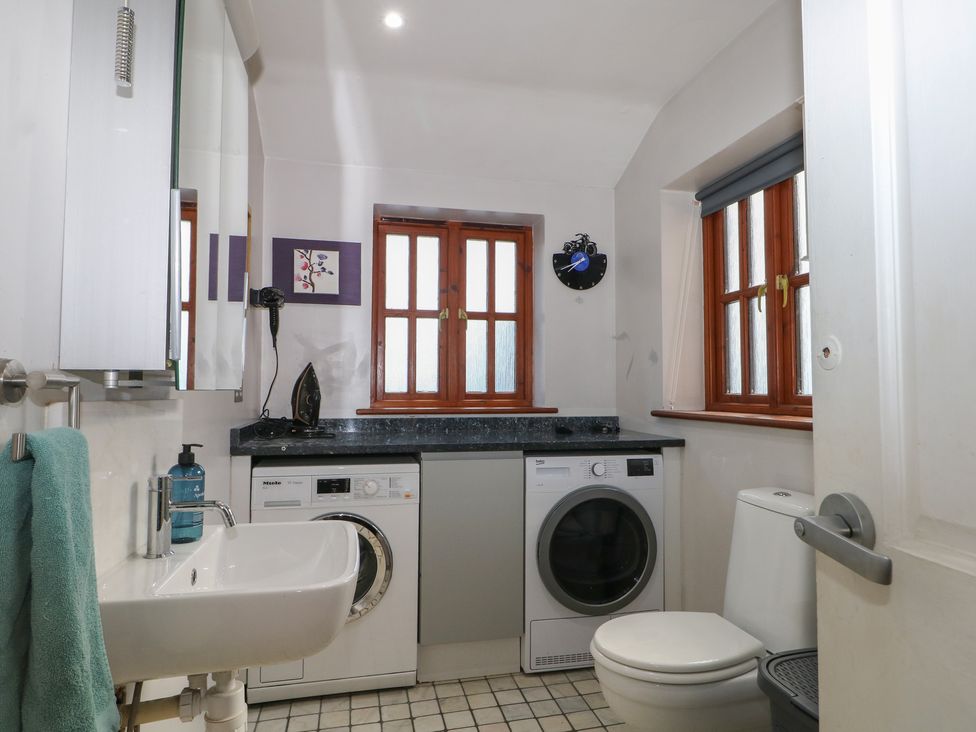 A bathroom with a washing machine and dryer at Tiffanys Coach House in Bournemouth