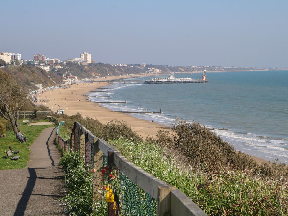 A beach view with a pier and path at Tiffanys Coach House in Bournemouth
