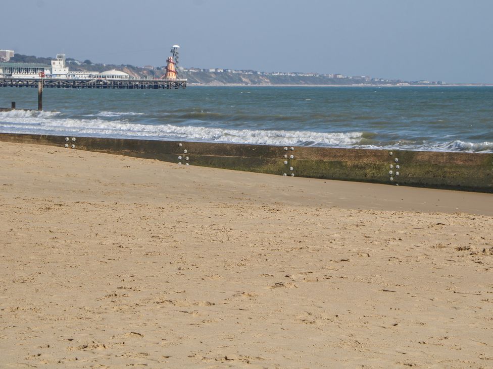 A beach with sand and water waves at Tiffanys Coach House Bournemouth