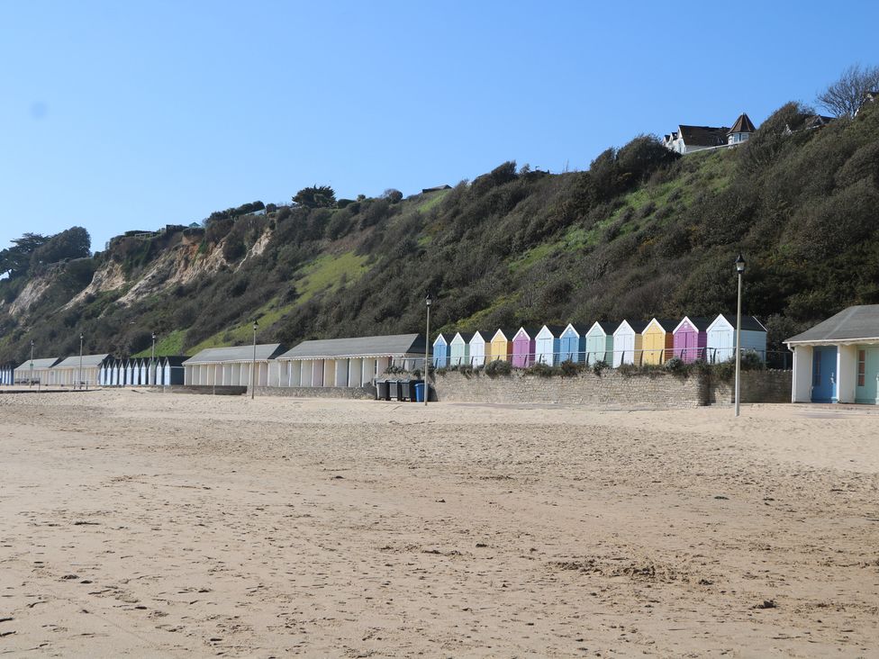 A beach with colorful beach huts and cliffs at Tiffanys Coach House in Bournemouth