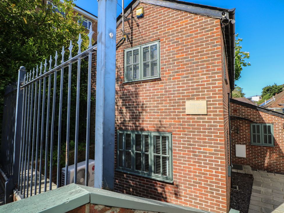 An exterior view of a brick building with green windows at Tiffanys Coach House in Bournemouth