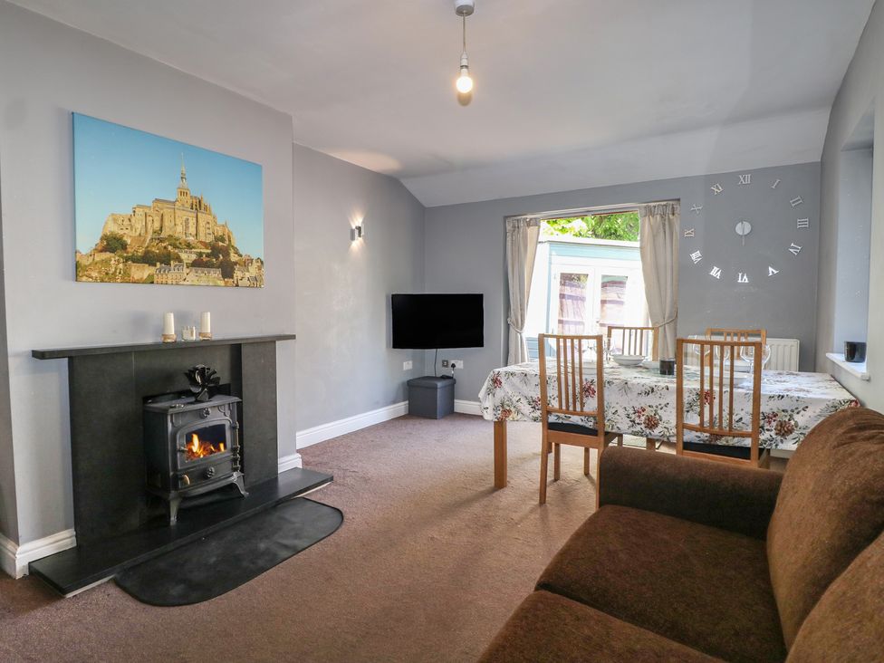 A living room with a dining table and a fireplace at Tiffanys Coach House in Bournemouth