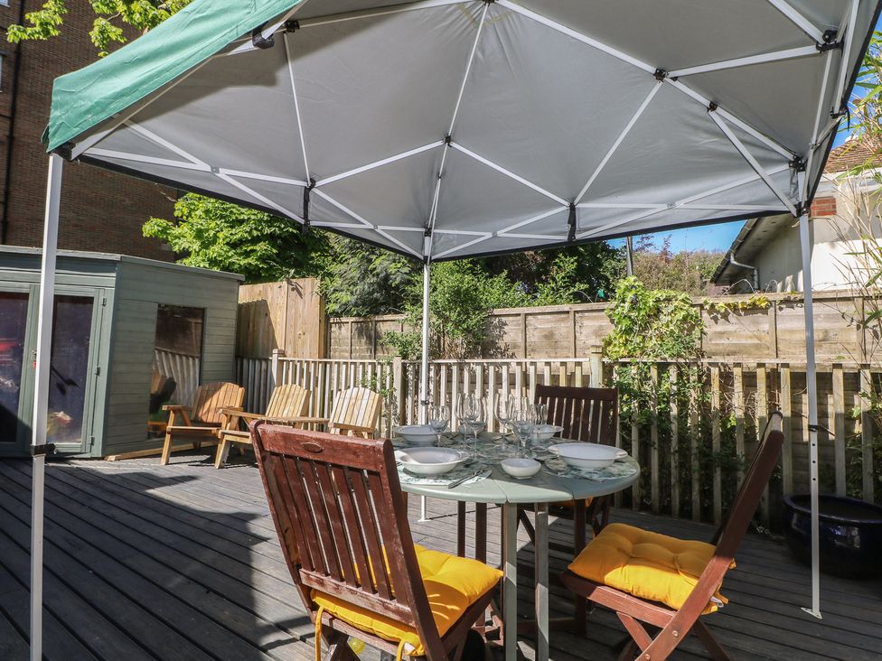 A patio area with a table and chairs under a canopy at Tiffanys Coach House in Bournemouth