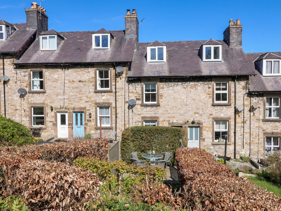 An outdoor area with houses and a garden table at 7 Catcliffe Cottages in Bakewell