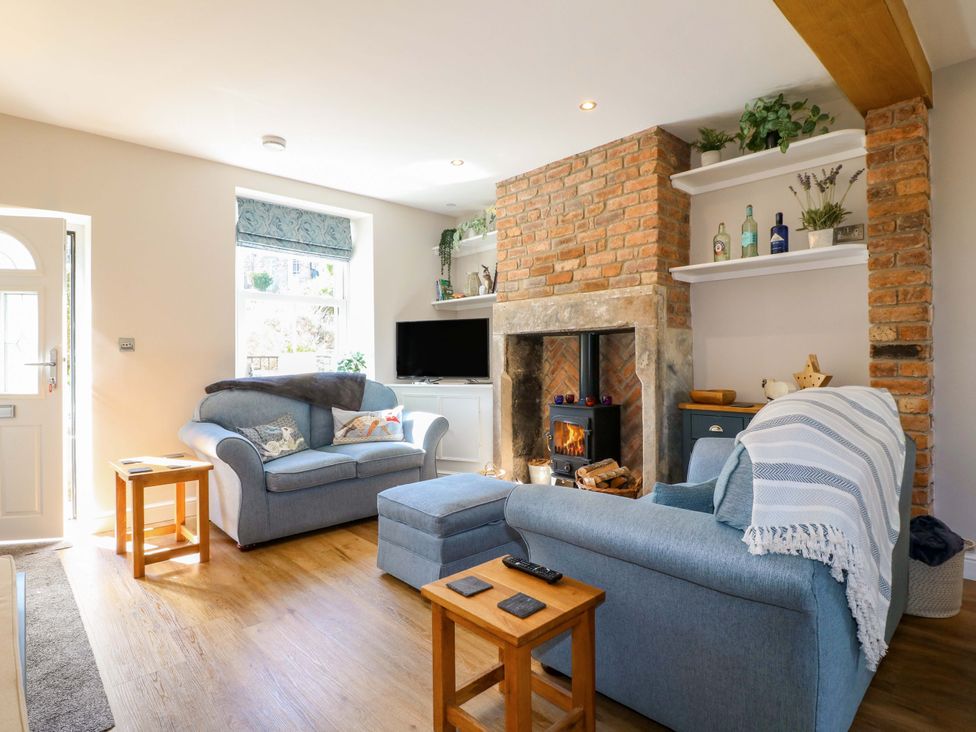 A living room with a sofa and fireplace at 7 Catcliffe Cottages in Bakewell
