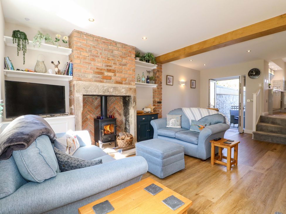 A living room with a fireplace and television at 7 Catcliffe Cottages Bakewell