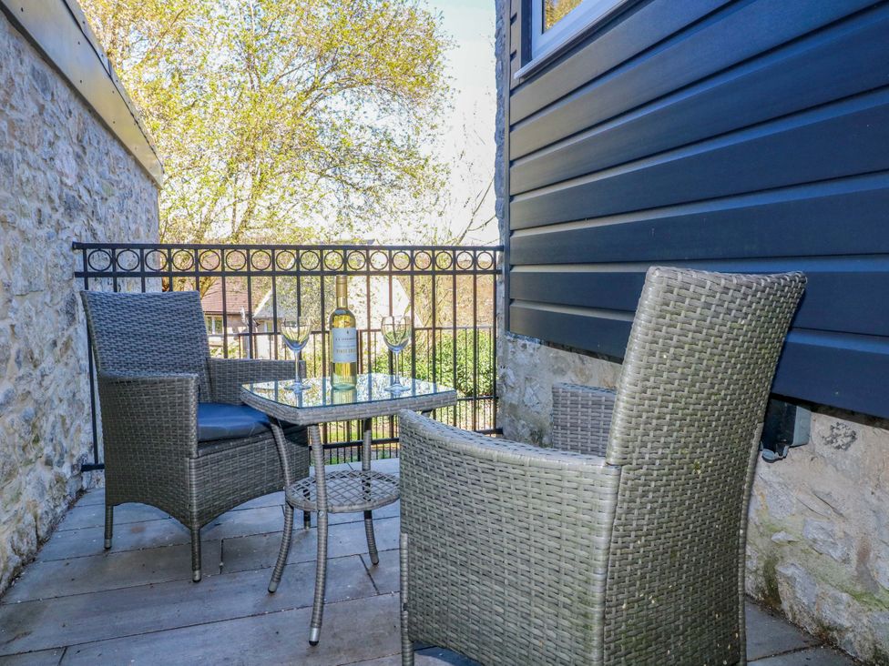 A balcony with chairs and a table at 7 Catcliffe Cottages in Bakewell